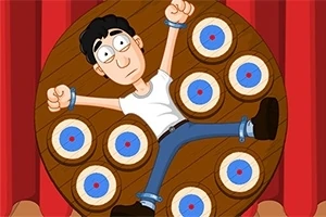 Dart Wheel Mężczyzna przywiązany do obrotowej planszy z tarczami do rzucania nożami w tle, z wyrazem niepokoju na twarzy