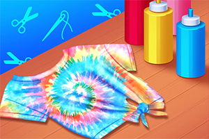 Koszulka w stylu tie-dye z kolorowym, spiralnym wzorem, znajdująca się na stole obok butelek z farbami