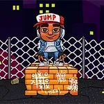 Chłopiec w czapce z napisem JUMP stoi na cegłach przed siatką ogrodzeniową z kolorowymi budynkami w tle
