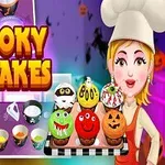 Kobieta w stroju kucharza trzyma tacę z kolorowymi, halloweenowymi babeczkami na tle kuchennym
