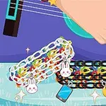 Ręka grająca na gitarze z kolorowymi bransoletkami z zawieszkami w kształcie królika, księżyca i telefonu